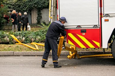 Dnepropetrovsk, Ukrayna -09.20.2021: Beş katlı bir binanın en üst katında yangın. Yangın söndürme sırasında su ve köpük kontrol paneli operatörünün işi.