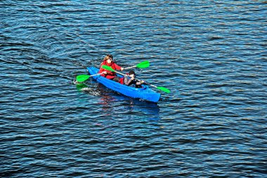 Dnepropetrovsk, Ukrayna - 10.31.2021: Gençler Dinyeper Nehri 'nde kano sporu yapıyor. Suyun sonbahar sarısı tonları. Spor. Sağlıklı yaşam tarzı kavramı.