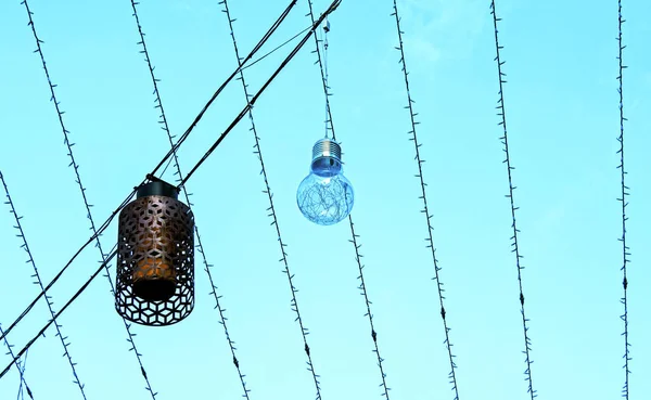 Hangende Verlichting Straten Kerst Bloemenslingers Een Achtergrond Van Blauwe Lucht — Stockfoto