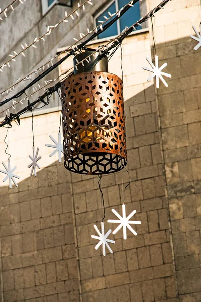 Hangende Verlichting Straten Kerst Bloemenslingers Achtergrond Van Bouwmuur Detailhandel — Stockfoto