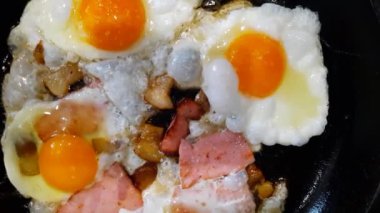 Yağlı ve sosisli omlet pişirme işlemi. Çırpılmış yumurtalar hazır. Kızarmış tavada domuz yağlı yumurta..