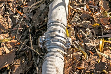 Bir bağlantı ve kablo kullanarak göletten su pompalamak için boruların bağlantısı. Zamanla, kablolar paslanır ve borular sızar..