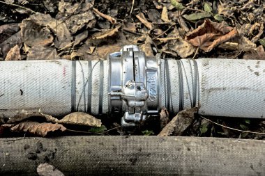 Bir bağlantı ve kablo kullanarak göletten su pompalamak için boruların bağlantısı. Zamanla, kablolar paslanır ve borular sızar..