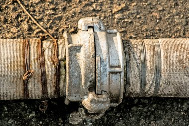 Bir bağlantı ve kablo kullanarak göletten su pompalamak için boruların bağlantısı. Zamanla, kablolar paslanır ve borular sızar..