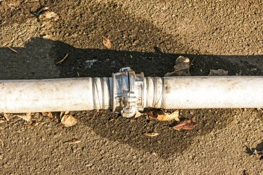 Bir bağlantı ve kablo kullanarak göletten su pompalamak için boruların bağlantısı. Zamanla, kablolar paslanır ve borular sızar..