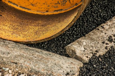 Küçük buharlı silindirler asfaltı dümdüz etmiş. Asfalt kaldırımda ağır titreşimli silindir çalışıyor. Tekerlek parçası, şehir yolu yapım aşamasında, asfaltlama devam ediyor.