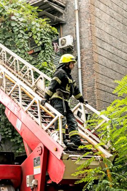 Dnepropetrovsk, Ukrayna -09.20.2021: Beş katlı bir binada yangın. Bir itfaiyeci yangını söndürdükten sonra yangın merdiveninden iniyor..