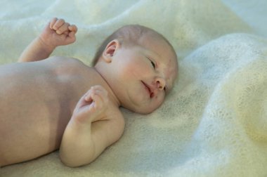 Yeni doğmuş bebek yatakta yatıyor. Bebek daha iki haftalık oldu. Yeni doğan bakım konsepti.