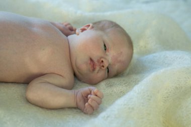 Yeni doğmuş bebek yatakta yatıyor. Bebek daha iki haftalık oldu. Yeni doğan bakım konsepti.