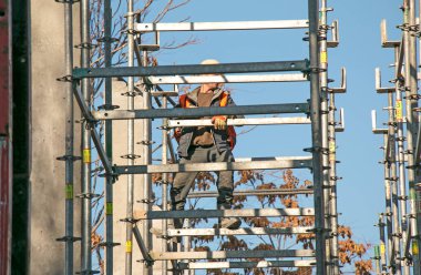 Dnepropetrovsk, Ukrayna - 10.26.2021: Bir işçi iskelenin yapı kalitesini kontrol eder .