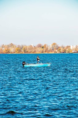 Dnepropetrovsk, Ukraine - 10.31.2021: Fisherman in a motor boat on the river, autumn.