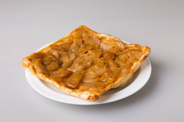 Beyaz bir tabakta karamelize edilmiş armut turtası. Minimalizm kavramı.