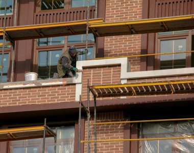 Dnipropetrovsk, Ukrayna - 11.22.2021: İnşaatçılar iskelenin ön cephesinin işlerini tamamlıyorlar