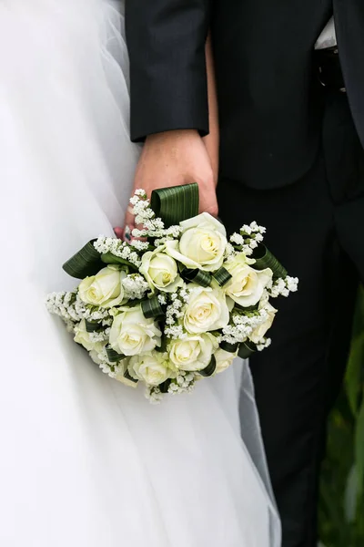 新娘和新郎肩并肩地站在一起 举行了一场婚礼 丈夫和妻子在结婚当天捧着花 — 图库照片