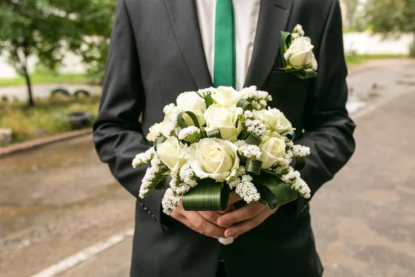 一个男人手里拿着结婚花束 情人节的概念 婚礼的概念 新郎带着一束花 穿西装的新郎拿着结婚花束 新娘的花束 — 图库照片