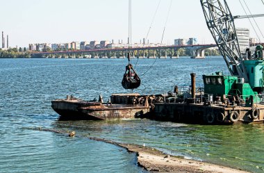 Yeni kurulan adayı Dnieper Nehri 'ndeki endüstriyel atıklardan temizliyorum. Modern nehirlerin çevresel sorunları. Ekoloji kavramı.
