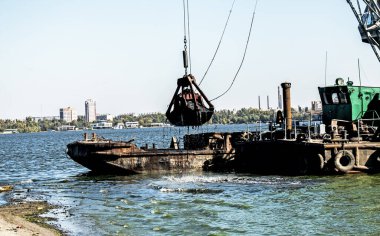 Yeni kurulan adayı Dnieper Nehri 'ndeki endüstriyel atıklardan temizliyorum. Modern nehirlerin çevresel sorunları. Ekoloji kavramı.