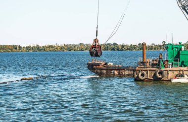 Yeni kurulan adayı Dnieper Nehri 'ndeki endüstriyel atıklardan temizliyorum. Modern nehirlerin çevresel sorunları. Ekoloji kavramı.