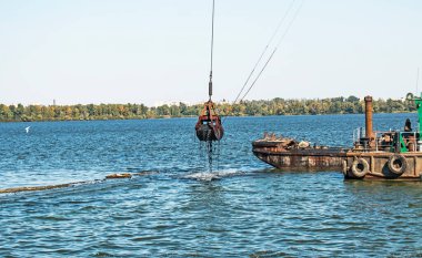 Yeni kurulan adayı Dnieper Nehri 'ndeki endüstriyel atıklardan temizliyorum. Modern nehirlerin çevresel sorunları. Ekoloji kavramı.
