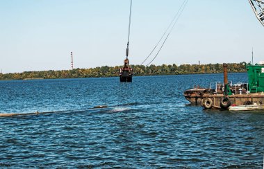 Yeni kurulan adayı Dnieper Nehri 'ndeki endüstriyel atıklardan temizliyorum. Modern nehirlerin çevresel sorunları. Ekoloji kavramı.