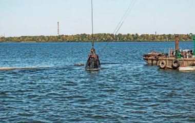 Yeni kurulan adayı Dnieper Nehri 'ndeki endüstriyel atıklardan temizliyorum. Modern nehirlerin çevresel sorunları. Ekoloji kavramı.