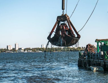 Yeni kurulan adayı Dnieper Nehri 'ndeki endüstriyel atıklardan temizliyorum. Modern nehirlerin çevresel sorunları. Ekoloji kavramı.