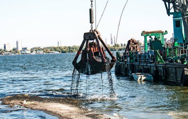 Yeni kurulan adayı Dnieper Nehri 'ndeki endüstriyel atıklardan temizliyorum. Modern nehirlerin çevresel sorunları. Ekoloji kavramı.