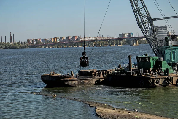Yeni kurulan adayı Dnieper Nehri 'ndeki endüstriyel atıklardan temizliyorum. Modern nehirlerin çevresel sorunları. Ekoloji kavramı.