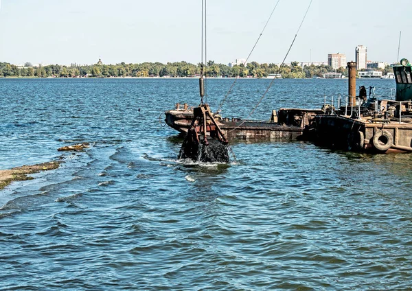 Yeni kurulan adayı Dnieper Nehri 'ndeki endüstriyel atıklardan temizliyorum. Modern nehirlerin çevresel sorunları. Ekoloji kavramı.