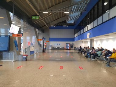 Bodrum, Türkiye - 10.17.2021: Milas-Bodrum Uluslararası Havalimanı içi. Havaalanı terminalinde yürüyen maskeli turistler. Coronavirus covid-19 salgını sırasında güvenlik önlemleri.