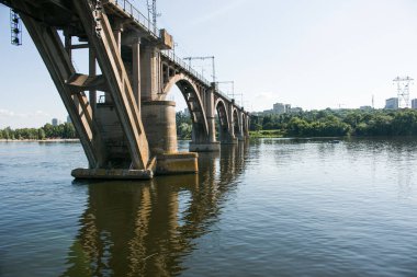 Yazın nehir boyunca kemerli demiryolu köprüsü. Dinyeper nehri üzerindeki Merefo-Kherson köprüsü. Dnepropetrovsk, Ukrayna.
