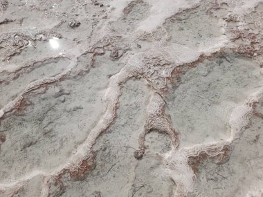 Travertin yüzeyinin dokusuna sahip arka plan - beyaz kireçtaşının üzerindeki kırmızı mineral çizgisi - deniz tabanındaki mercan gibi. Pamukkale Ulusal Parkı, Türkiye.