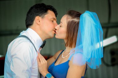 Evlilik yıldönümlerini kutlayan, düğün kıyafetli genç bir çiftin portresi. Gülümse, öp, sev.