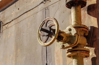 Duvarda eski paslı gaz kontrol vanası var. Büyük bir sistemde endüstriyel bir vana. Ukrayna 'nın gaz iletim sistemi çöküyor..