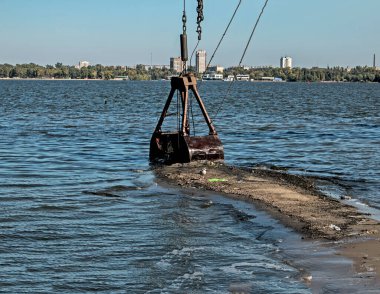 Özel bir tarağın kovası yapay adayı temizler. Dinyeper Nehri 'nin kıyı sularında ekolojik felaket.