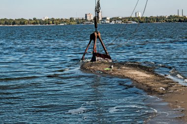 Özel bir tarağın kovası yapay adayı temizler. Dinyeper Nehri 'nin kıyı sularında ekolojik felaket.