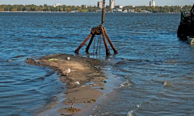 Özel bir tarağın kovası yapay adayı temizler. Dinyeper Nehri 'nin kıyı sularında ekolojik felaket.