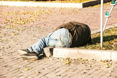 Dnipropetrovsk, Ukrayna - 10.31.2021: Evsiz bir adam kaldırımda uyuyor.