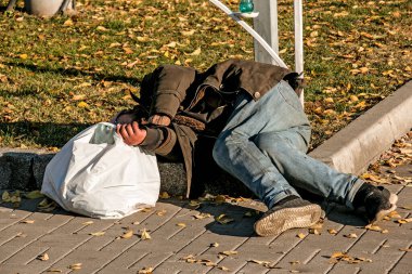 Dnipropetrovsk, Ukrayna - 10.31.2021: Evsiz bir adam kaldırımda uyuyor.