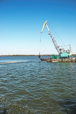 Yeni kurulan adayı Dnieper Nehri 'ndeki endüstriyel atıklardan temizliyorum. Modern nehirlerin çevresel sorunları. Ekoloji kavramı.
