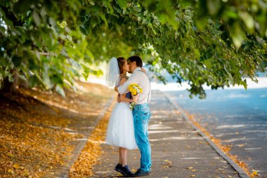 Evlilik yıldönümlerini kutlayan, düğün kıyafetli genç bir çiftin portresi. Gülümse, öp, sev.