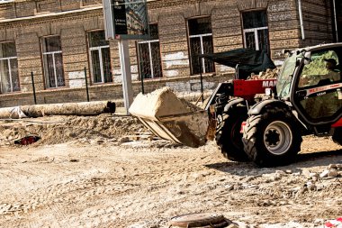 Dnepropetrovsk, Ukrayna - 10.05.2021: Grader kumu çıkarır. İnşaat işçileri alanı hazırlıyor..