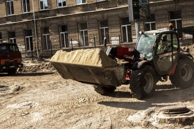 Dnepropetrovsk, Ukrayna - 10.05.2021: Grader kumu çıkarır. İnşaat işçileri alanı hazırlıyor..