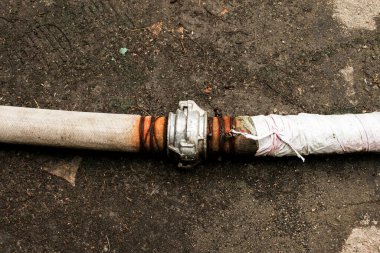 Bir bağlantı ve kablo kullanarak göletten su pompalamak için boruların bağlantısı. Zamanla, kablolar paslanır ve borular sızar..