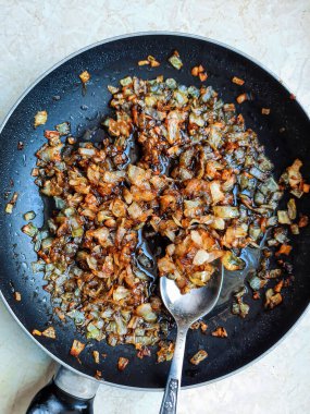 Beyaz arka plan üzerinde izole bir tavada kızartma soğan