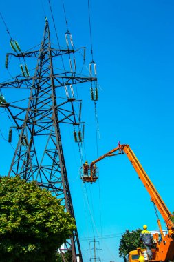 Dnipropetrovsk, Ukrayna - 08.08.2021: güç aktarım hatlarının onarımı. Kulelerin yardımıyla işçiler güç aktarım hatlarını onarıyor.