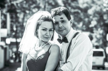 Evlilik yıldönümlerini siyah beyaz kutlayan düğün kıyafetli genç bir çiftin portresi. Gülümse, öp, buketi bir arada tut, aşkım.