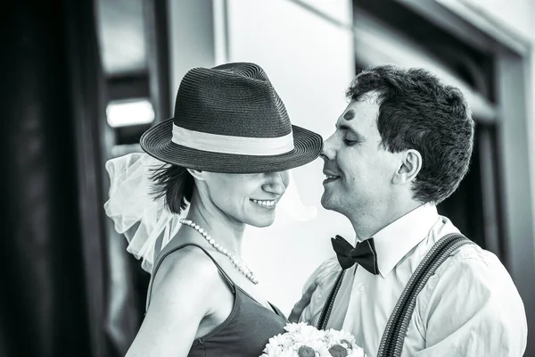 Evlilik yıldönümlerini siyah beyaz kutlayan düğün kıyafetli genç bir çiftin portresi. Gülümse, öp, buketi bir arada tut, aşkım.