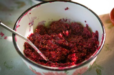 Kadın kırmızı üzümlü reçel hazırlıyor, kadın bulaşıklar için marmelat yapıyor, sağlıklı beslenme ve pişirme konsepti.