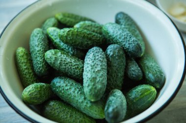 Kış için salatalık turşusunu koruma süreci. Yıkanmış salatalıklar konteynırda hazırlanır..